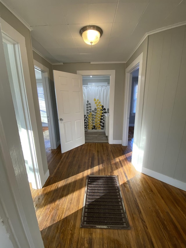 hall with crown molding, hardwood / wood-style floors, and visible vents