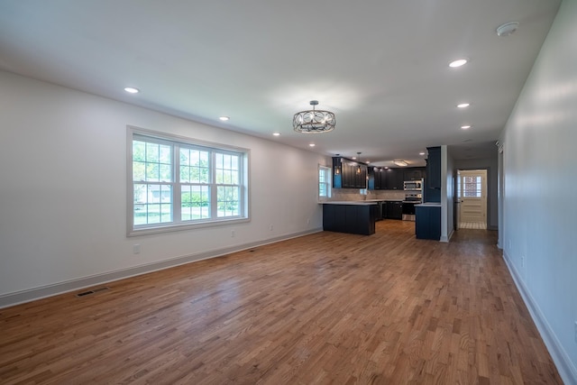 unfurnished living room with plenty of natural light, recessed lighting, and visible vents