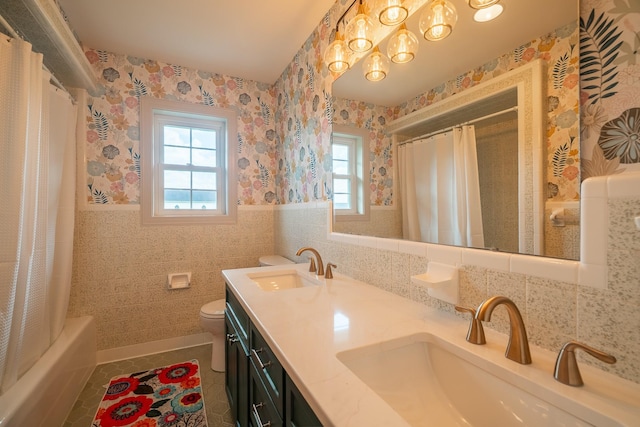 full bath with a sink, tile walls, tile patterned flooring, and toilet