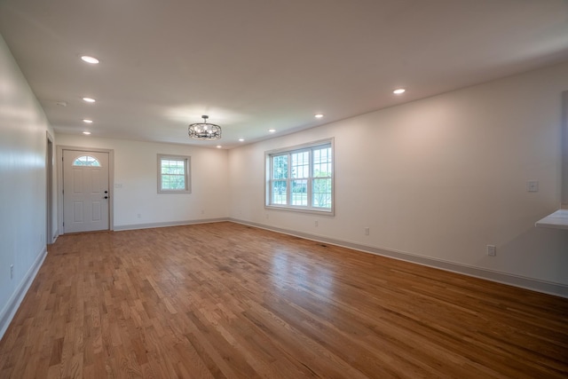 interior space featuring recessed lighting, baseboards, a chandelier, and wood finished floors