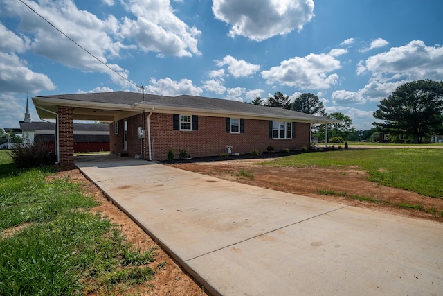 single story home with brick siding, a front lawn, an attached carport, and concrete driveway