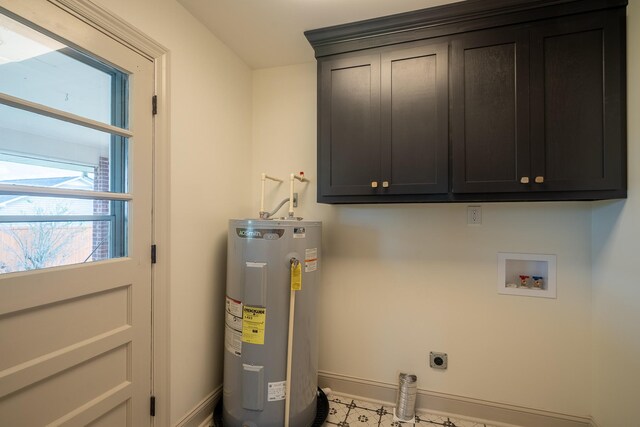clothes washing area featuring baseboards, hookup for a washing machine, cabinet space, water heater, and hookup for an electric dryer