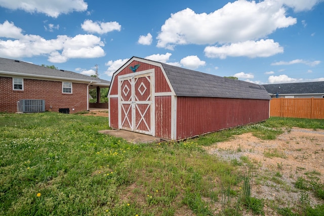 view of shed featuring central air condition unit and fence