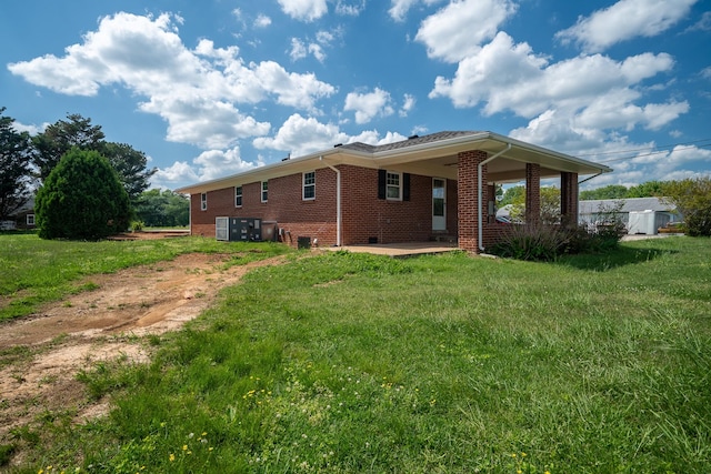 back of property featuring a lawn, brick siding, and a patio area
