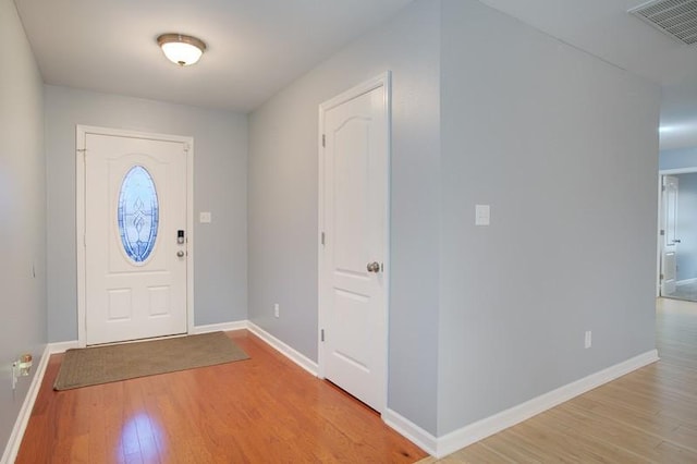 entryway with light wood-type flooring, baseboards, and visible vents