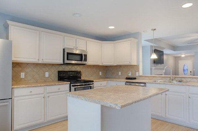 kitchen featuring a sink, light wood-style flooring, appliances with stainless steel finishes, and white cabinetry