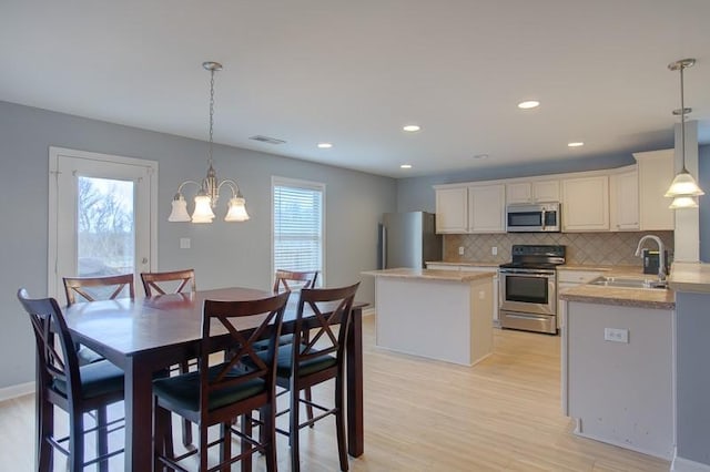 dining space with an inviting chandelier, recessed lighting, baseboards, light wood-type flooring, and visible vents