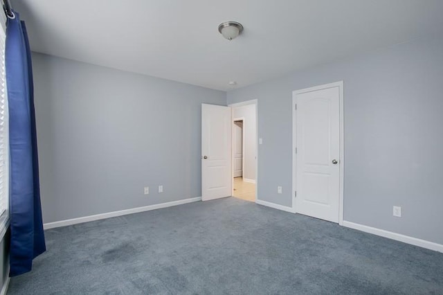 unfurnished bedroom featuring carpet flooring and baseboards