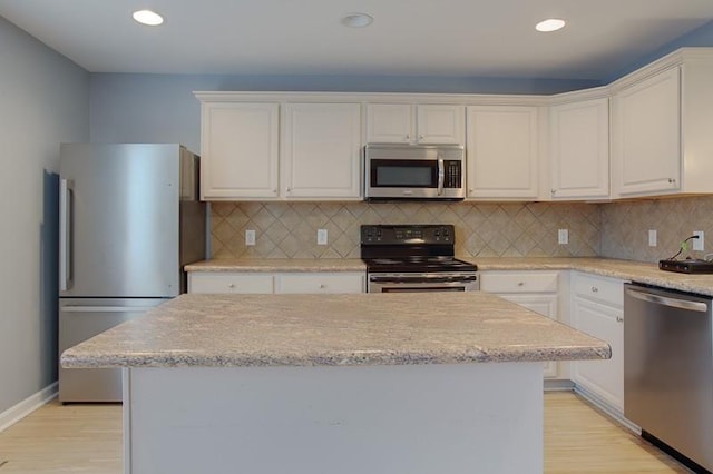 kitchen with backsplash, light wood finished floors, stainless steel appliances, recessed lighting, and white cabinetry