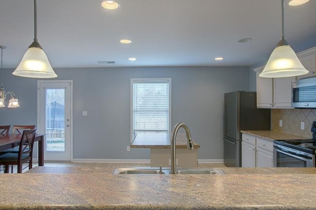 kitchen with a sink, backsplash, a healthy amount of sunlight, and stainless steel appliances