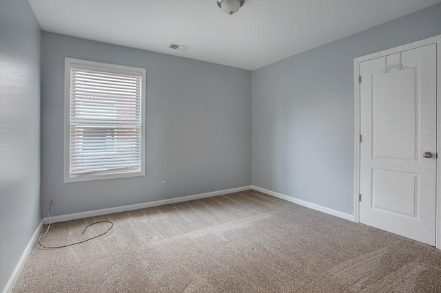 carpeted empty room with baseboards and visible vents