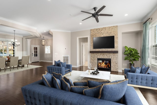 living area with a stone fireplace, visible vents, wood finished floors, ceiling fan with notable chandelier, and recessed lighting