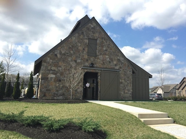 view of barn featuring a yard and fence