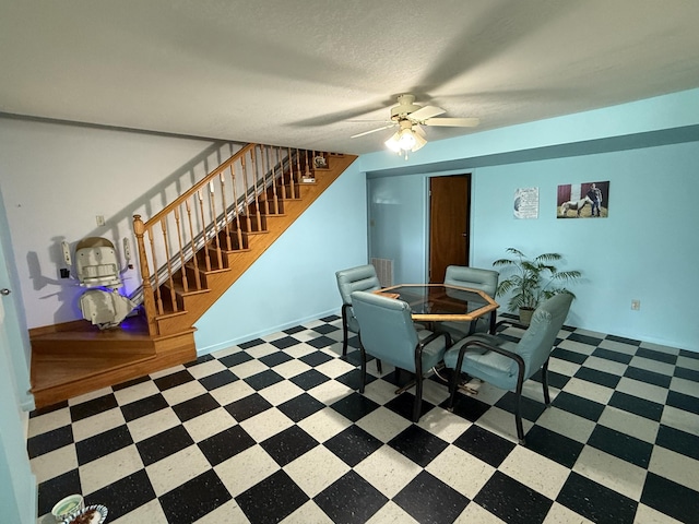 dining room featuring tile patterned floors, ceiling fan, and stairs