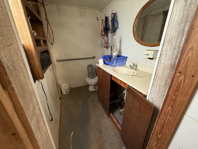 bathroom with vanity, concrete flooring, and toilet
