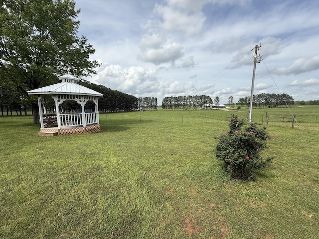 view of yard with fence, a gazebo, and a rural view