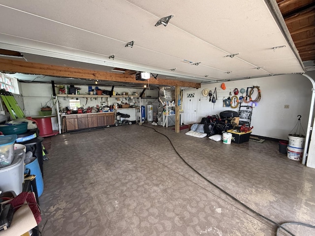 garage with water heater, a workshop area, and a garage door opener