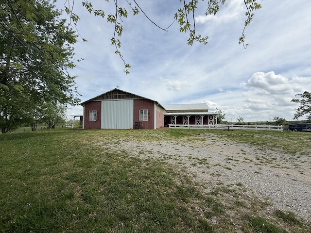 view of pole building with a yard and fence