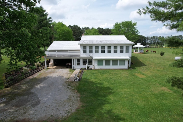 view of front of property with a gazebo, a front lawn, gravel driveway, and metal roof