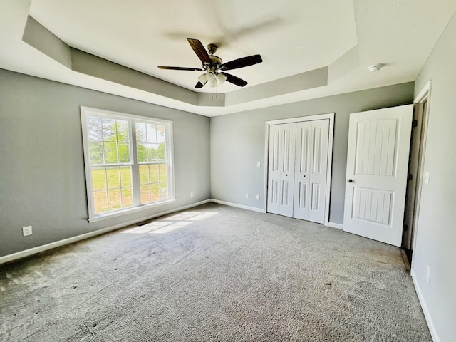 436 White Rd, Leoma, TN 38468 - unfurnished bedroom featuring a closet, baseboards, carpet, and a tray ceiling