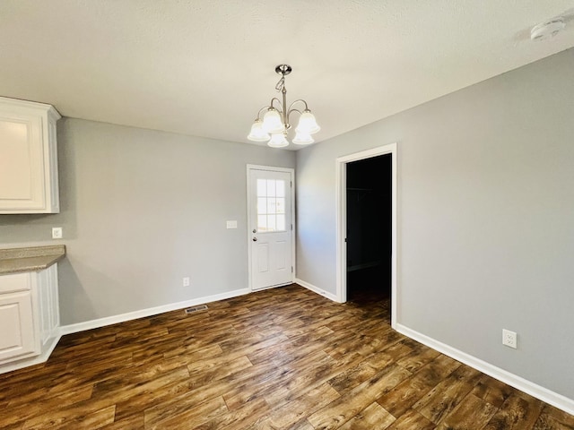 436 White Rd, Leoma, TN 38468 - unfurnished dining area featuring baseboards, dark wood-style flooring, and a notable chandelier