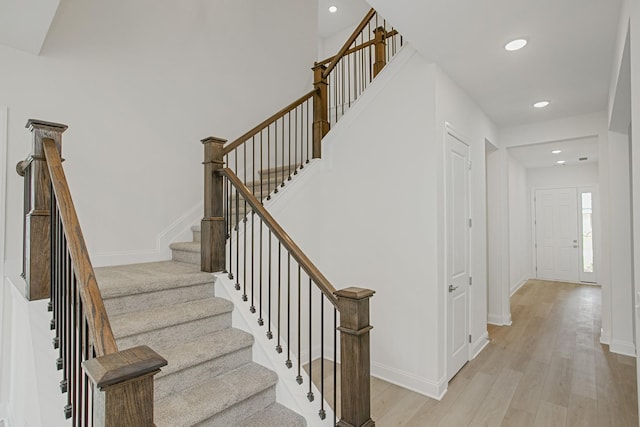 stairway featuring recessed lighting, baseboards, and wood finished floors