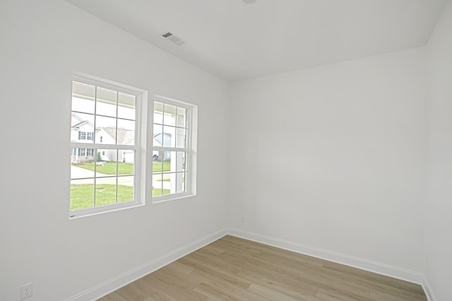 spare room with baseboards, visible vents, and light wood-type flooring