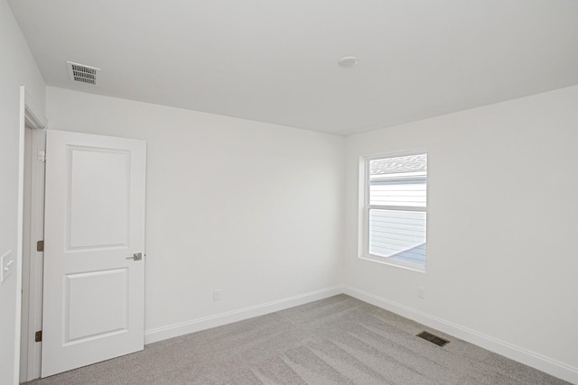 unfurnished room with light colored carpet, baseboards, and visible vents