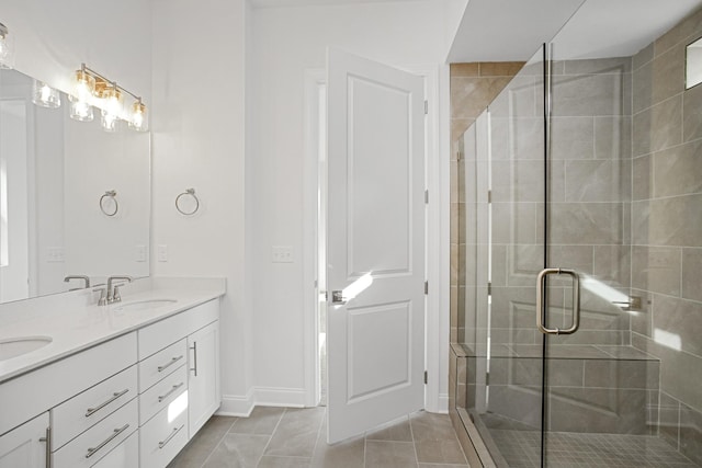 full bath featuring double vanity, tile patterned floors, a shower stall, and a sink