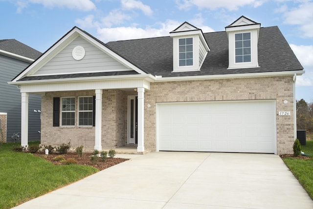 view of front facade featuring brick siding, a shingled roof, covered porch, and concrete driveway
