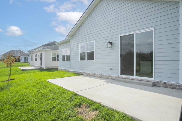 rear view of house with a lawn and a patio