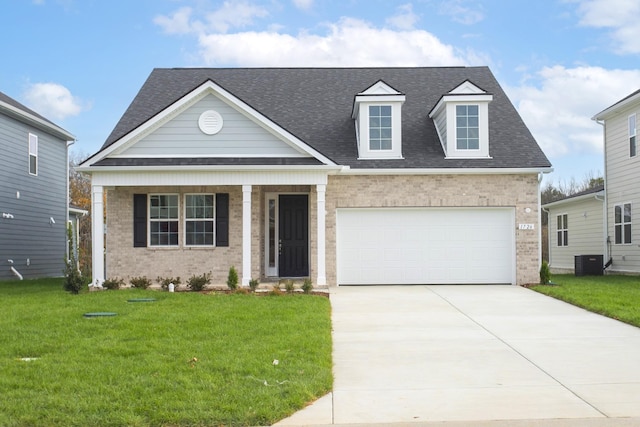 view of front of property with roof with shingles, brick siding, a porch, a front yard, and driveway