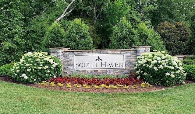 community / neighborhood sign with a yard