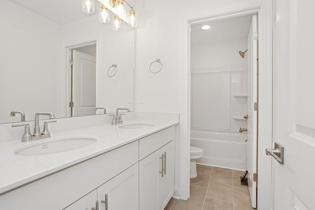 bathroom featuring double vanity, toilet, tile patterned floors, and a sink