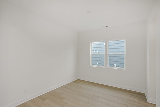 empty room featuring baseboards and light wood-style flooring