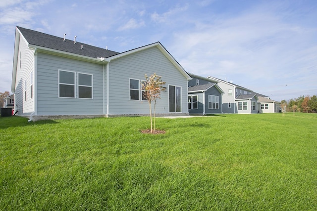 back of house with a yard and central air condition unit