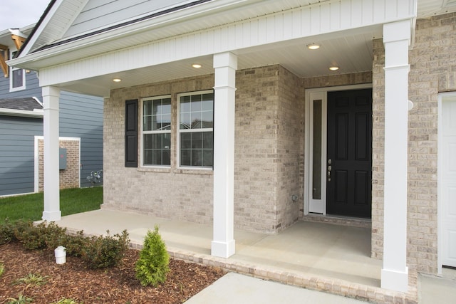 property entrance with covered porch and brick siding