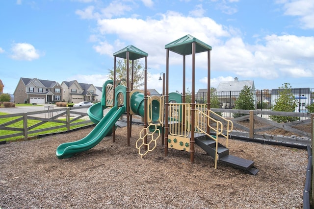 communal playground featuring fence and a residential view
