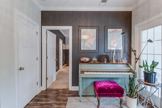 living area featuring visible vents, ornamental molding, baseboards, and wood finished floors