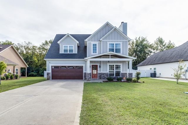 craftsman-style house with a front lawn, stone siding, board and batten siding, a chimney, and driveway