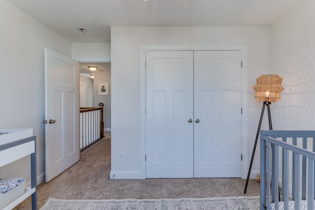 bedroom featuring baseboards, light carpet, and a closet