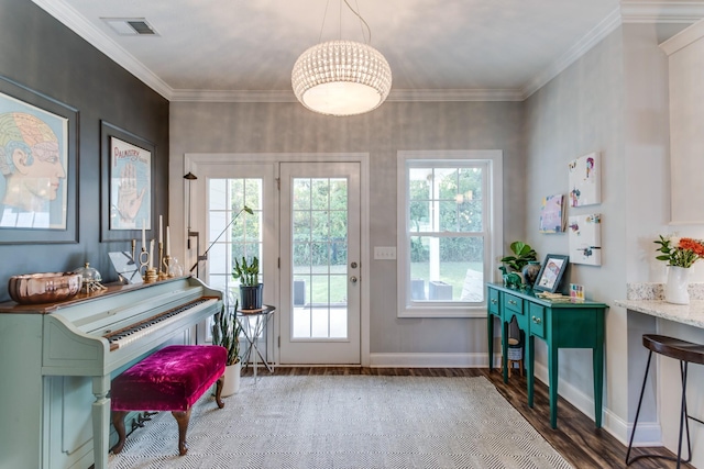 doorway to outside with baseboards, ornamental molding, wood finished floors, and visible vents
