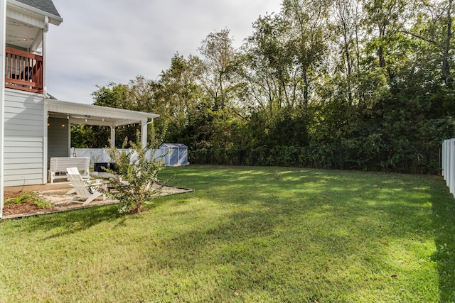 view of yard featuring a patio, a fenced backyard, a shed, and an outbuilding