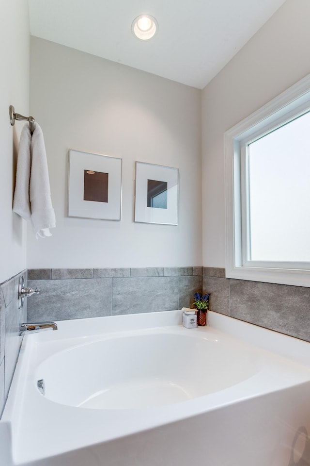 bathroom featuring recessed lighting and a bath
