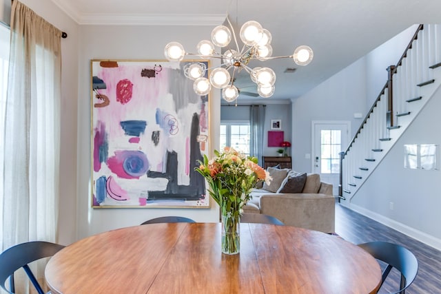 dining room with an inviting chandelier, baseboards, wood finished floors, ornamental molding, and stairway