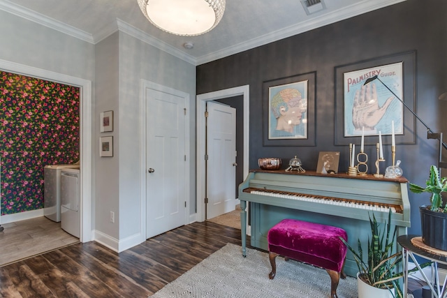 sitting room featuring visible vents, crown molding, wood finished floors, baseboards, and washer and clothes dryer