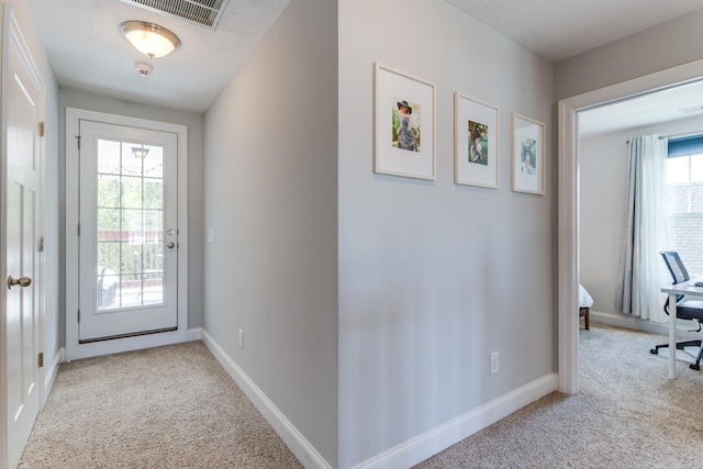 doorway featuring carpet floors, baseboards, and visible vents