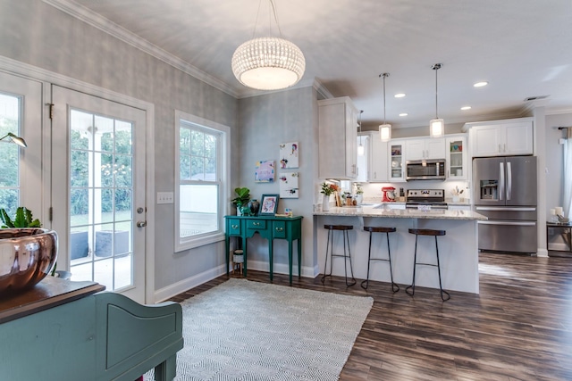 kitchen featuring crown molding, appliances with stainless steel finishes, white cabinets, a peninsula, and glass insert cabinets