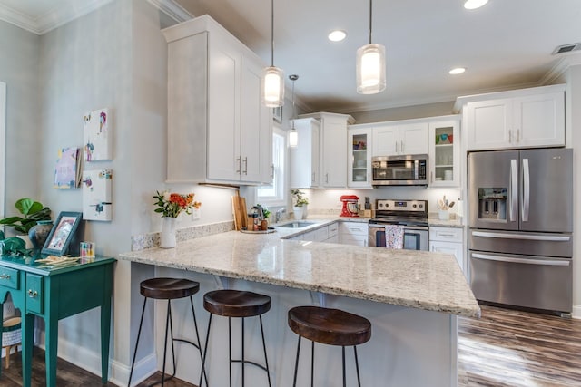 kitchen featuring crown molding, visible vents, a peninsula, dark wood finished floors, and stainless steel appliances