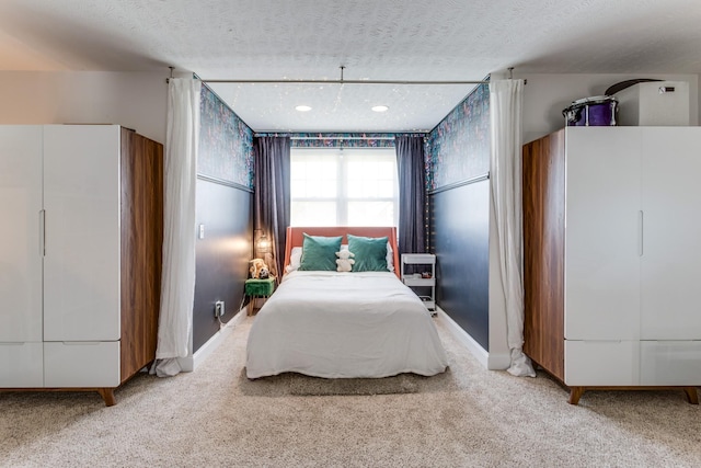 bedroom with carpet flooring, a textured ceiling, and baseboards